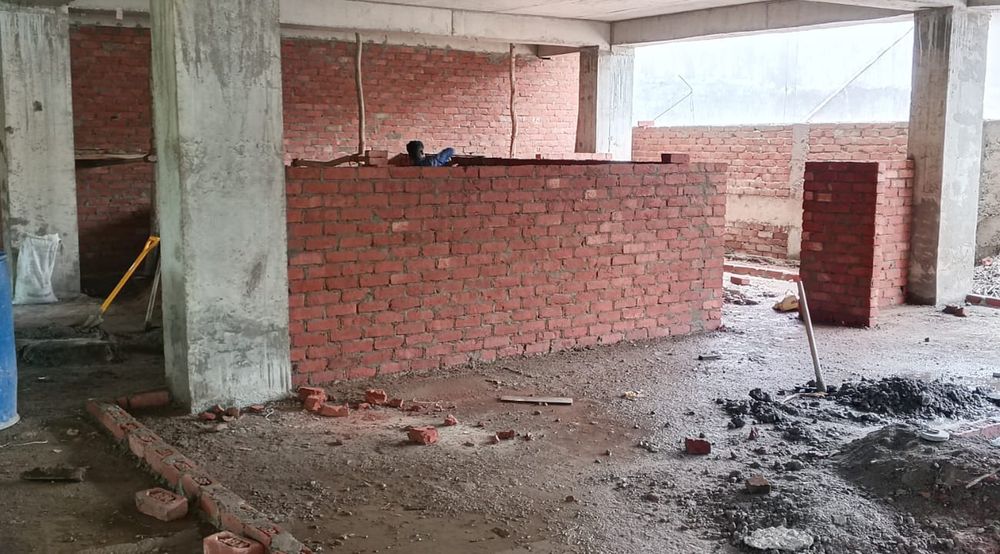 Brick walls going up between the columns inside the building